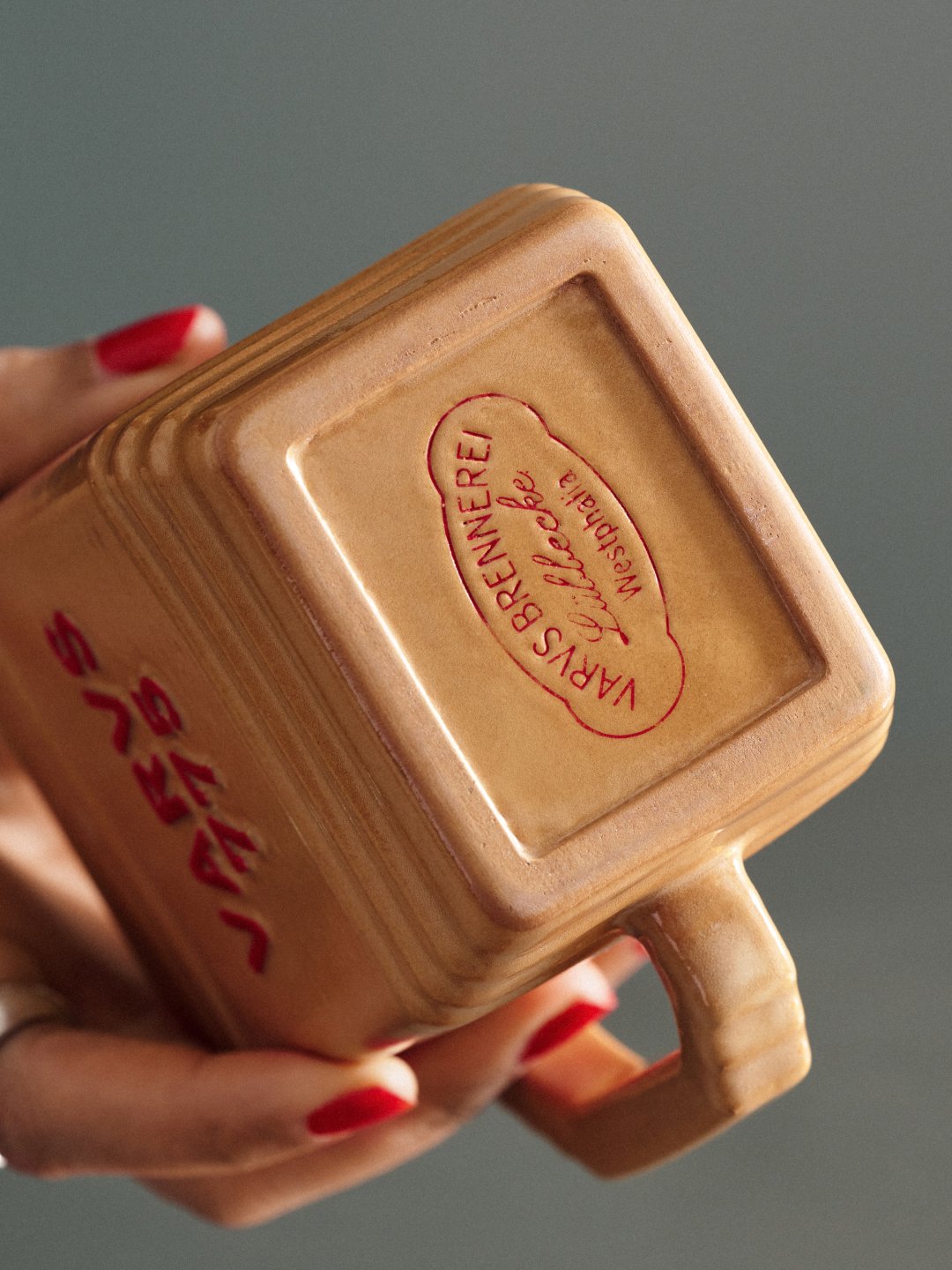 Close-up of bottle base with oval embossed mark and red-painted nails, Varus 775 by Olssøn Barbieri, Lübbecke, Olssøn Barbieri / Varus Brennerei, Lübbecke, Germany